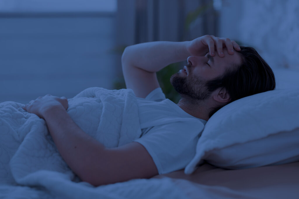 Neend na aane ki problem se pareshan aadmi raat me bed par jagta hua (insomnia symptoms)  Neend Na Aane Ka Ilaj